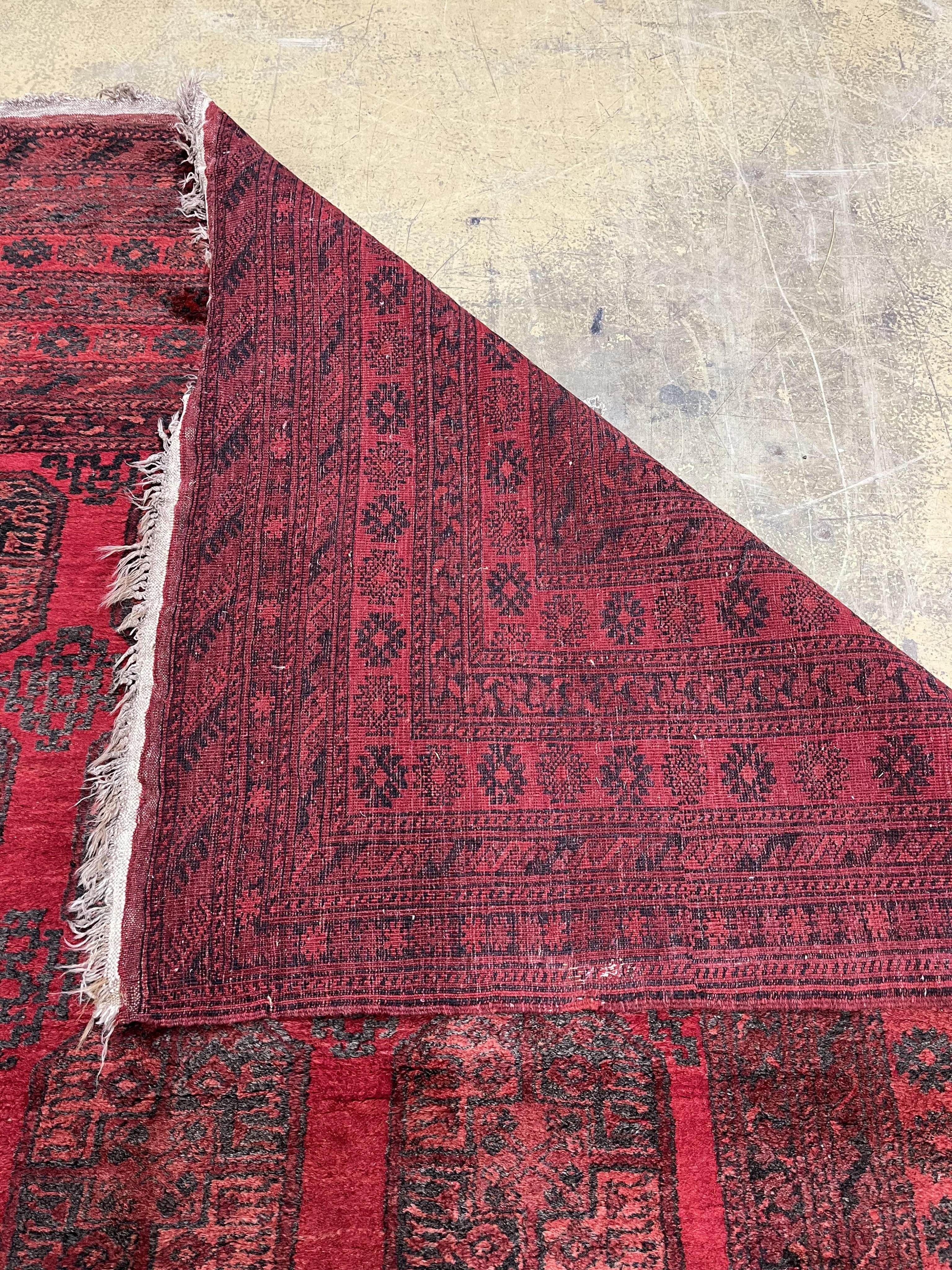 An Afghan red ground carpet, 330 x 240cm. Condition - fair